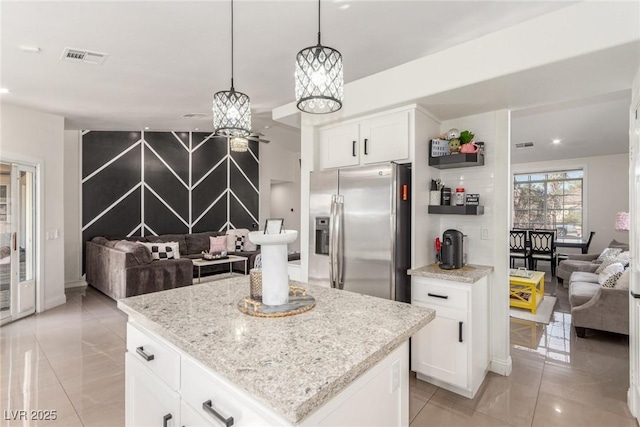 286 Fairmeadow St, Henderson, NV 89012 - kitchen with stainless steel fridge with ice dispenser, open floor plan, white cabinetry, light stone countertops, and recessed lighting