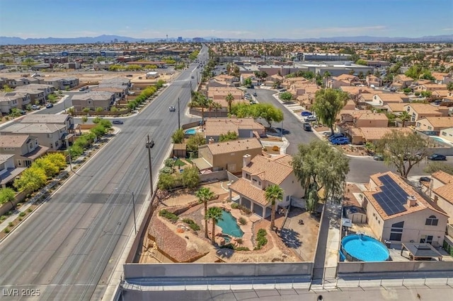 aerial perspective of suburban area featuring a pool area and a mountain backdrop