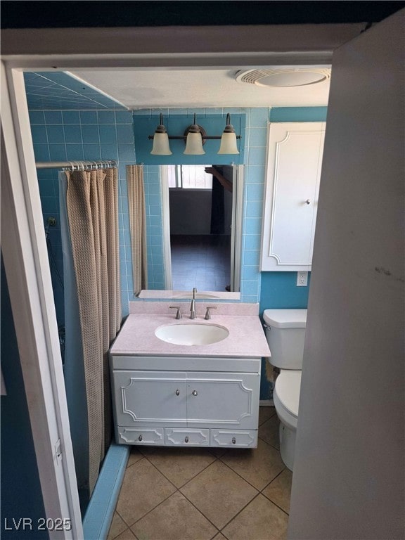 bathroom featuring tile patterned floors, vanity, toilet, and curtained shower