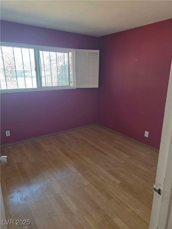 spare room with wood finished floors and baseboards