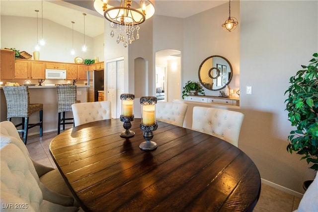 10336 Birch Bluff Ln, Las Vegas, NV 89145 - dining room featuring arched walkways, high vaulted ceiling, baseboards, and a chandelier