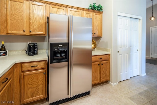 10336 Birch Bluff Ln, Las Vegas, NV 89145 - kitchen with stainless steel refrigerator with ice dispenser, light tile patterned flooring, light countertops, and brown cabinetry