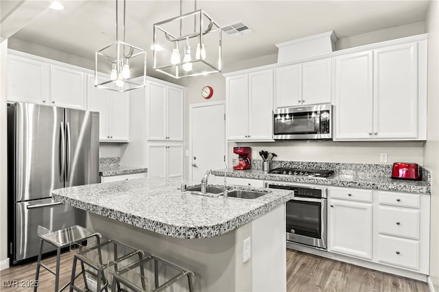 160 Lomita Heights Dr, Las Vegas, NV 89138 - kitchen with appliances with stainless steel finishes, a kitchen breakfast bar, white cabinets, a kitchen island with sink, and light wood-type flooring