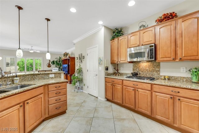 kitchen featuring appliances with stainless steel finishes, a sink, light stone countertops, backsplash, and decorative light fixtures