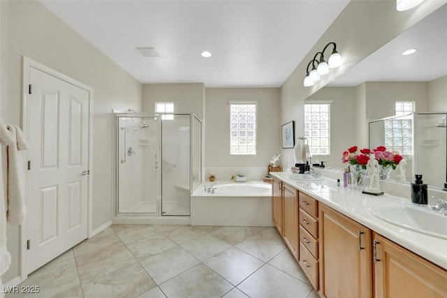 bathroom featuring a stall shower, a garden tub, double vanity, tile patterned flooring, and recessed lighting