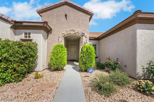 view of exterior entry featuring stucco siding