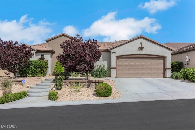 view of front facade with a garage, stucco siding, driveway, and a tiled roof
