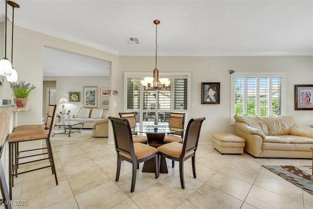 dining space featuring a chandelier, ornamental molding, light tile patterned floors, and baseboards
