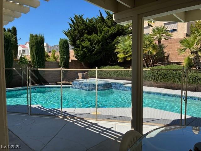 view of pool featuring a fenced backyard, a pool with connected hot tub, and a patio