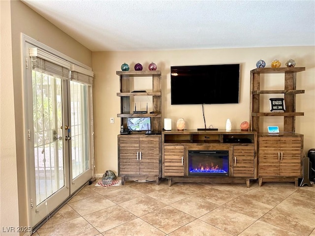living area featuring a glass covered fireplace and light tile patterned floors