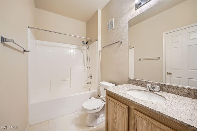 bathroom with toilet, vanity, washtub / shower combination, and a textured wall