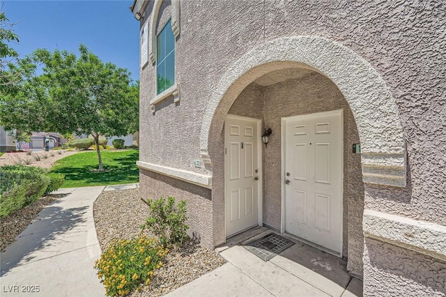 entrance to property featuring stucco siding
