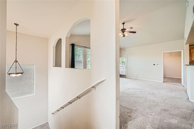corridor featuring light colored carpet and baseboards