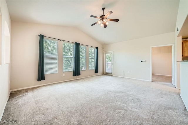 spare room with a ceiling fan, light colored carpet, lofted ceiling, and baseboards