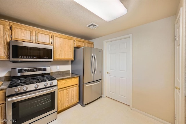 kitchen featuring stainless steel appliances and dark countertops