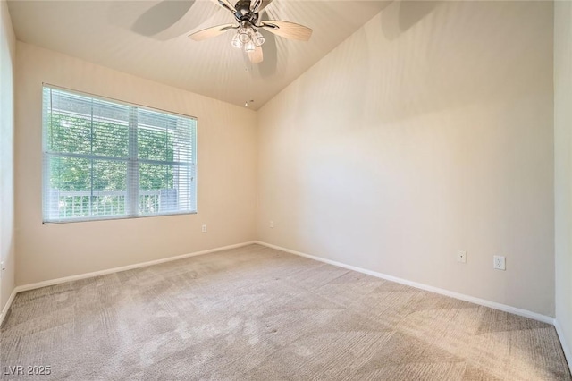 carpeted spare room featuring baseboards and a ceiling fan