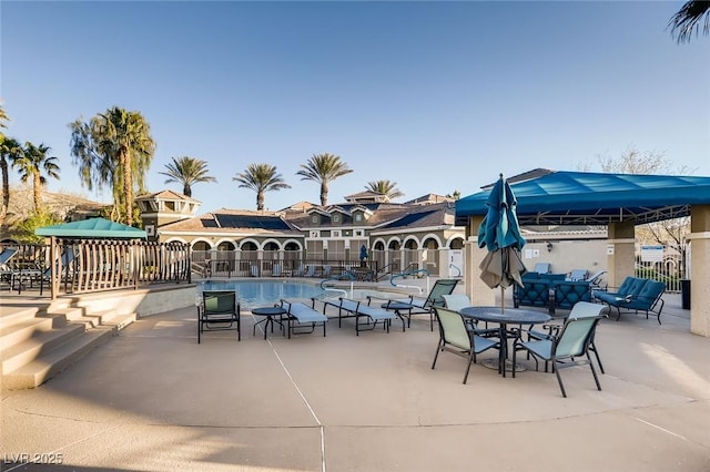 view of patio / terrace with fence and a community pool