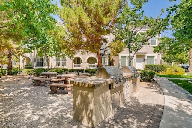view of home's community with area for grilling and a patio