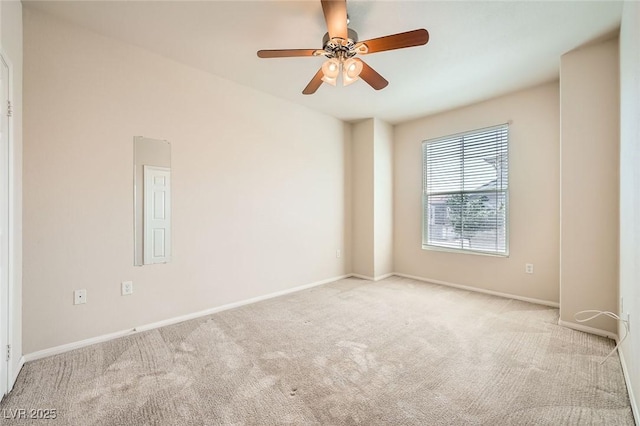 empty room featuring carpet flooring, a ceiling fan, and baseboards