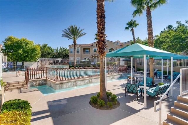 community pool featuring fence and a patio