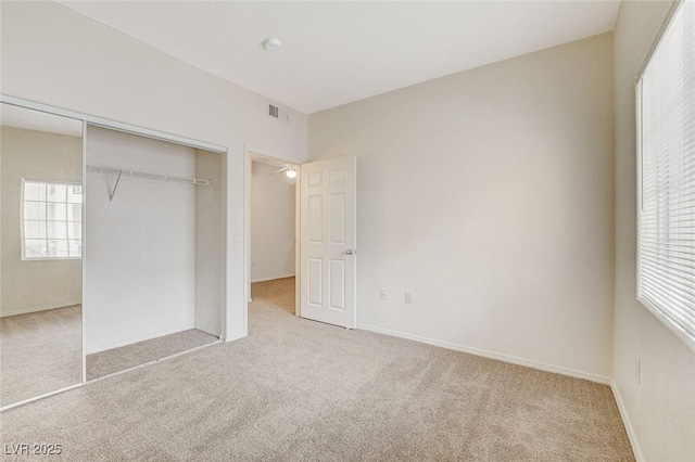 unfurnished bedroom featuring carpet, a closet, and baseboards