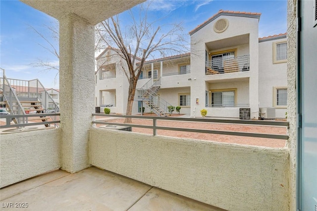 balcony featuring cooling unit and stairs