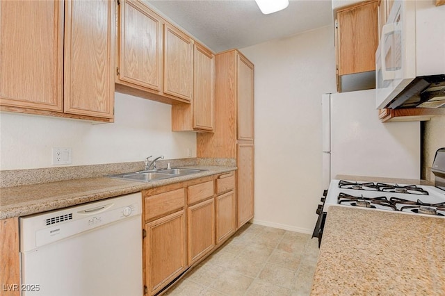 kitchen with white appliances, a sink, light brown cabinetry, light countertops, and baseboards