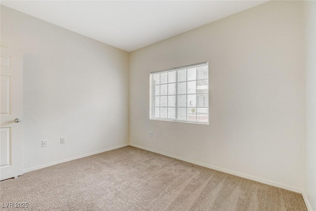 unfurnished room featuring light carpet and baseboards