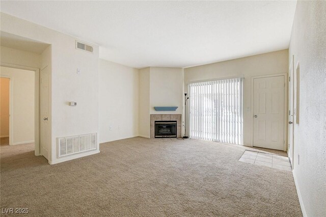 unfurnished living room with carpet floors and a tile fireplace