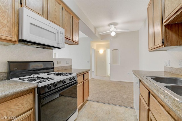 kitchen with white appliances, ceiling fan, light carpet, light countertops, and a sink