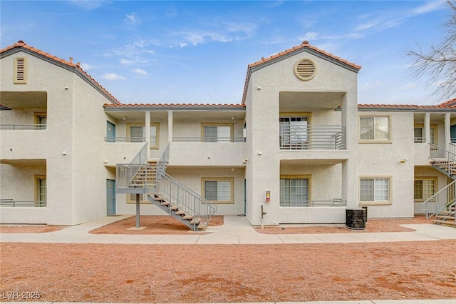 view of building exterior with stairs and cooling unit