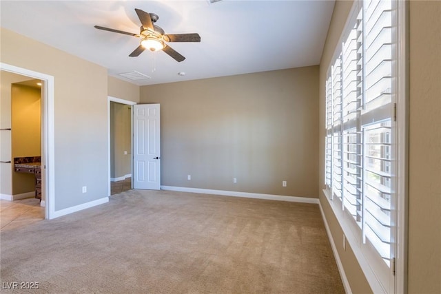 7434 Eggshell Dr, North Las Vegas, NV 89084 - unfurnished bedroom with light carpet, multiple windows, baseboards, and a ceiling fan
