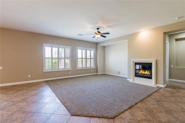 7434 Eggshell Dr, North Las Vegas, NV 89084 - unfurnished living room with tile patterned flooring, a glass covered fireplace, ceiling fan, and baseboards
