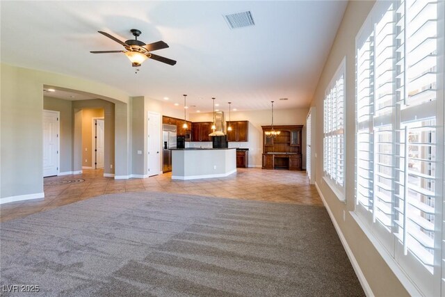 7434 Eggshell Dr, North Las Vegas, NV 89084 - unfurnished living room featuring light tile patterned floors, baseboards, a ceiling fan, and light carpet