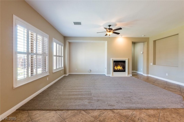 7434 Eggshell Dr, North Las Vegas, NV 89084 - unfurnished living room featuring tile patterned flooring, a ceiling fan, a fireplace with flush hearth, and carpet flooring