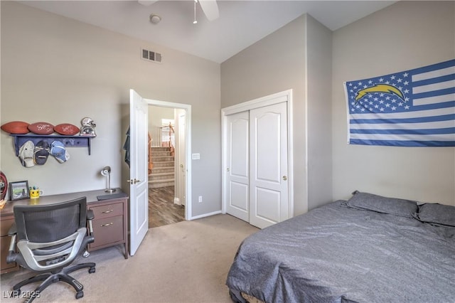 bedroom featuring a closet, light carpet, ceiling fan, and an office area