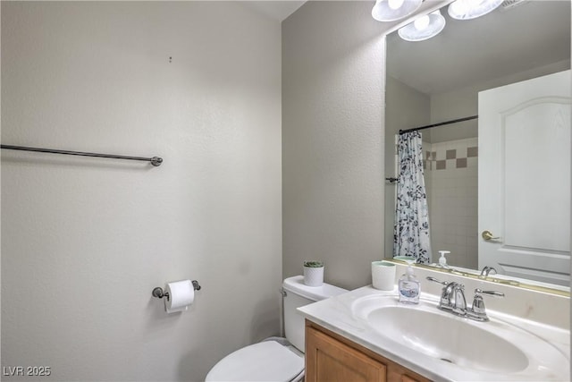 bathroom featuring toilet, vanity, and a shower with shower curtain