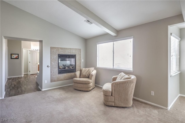 living area with carpet flooring, a tile fireplace, and baseboards