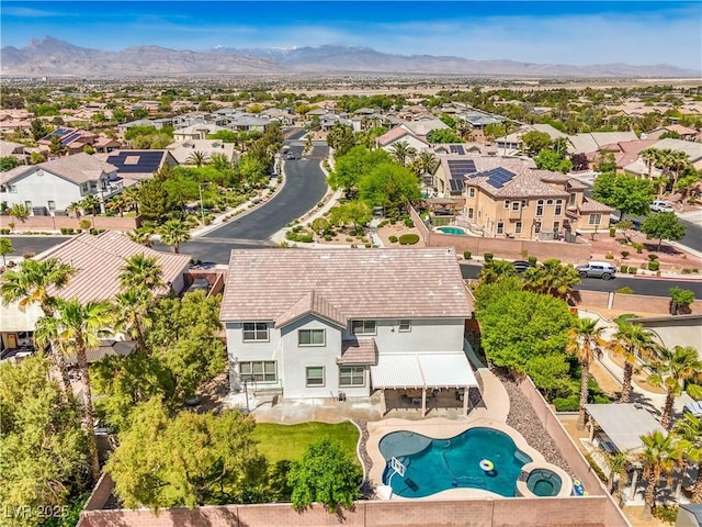 aerial view of residential area with a mountain backdrop and a pool area