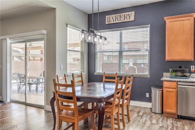 dining room featuring light wood finished floors and baseboards