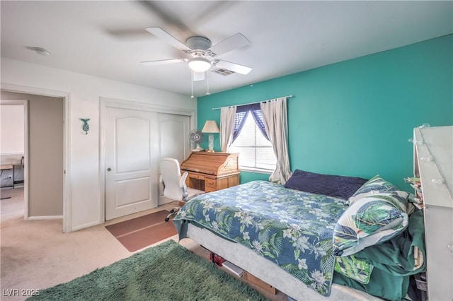 carpeted bedroom with a closet, a ceiling fan, and baseboards