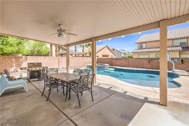 view of pool featuring a pool with connected hot tub, a grill, a fenced backyard, and a patio