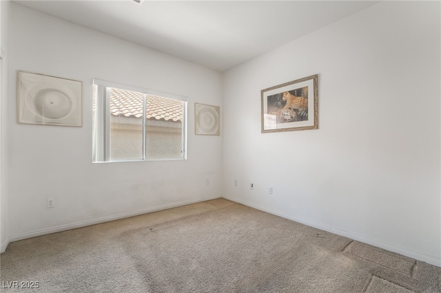 spare room featuring carpet floors and baseboards
