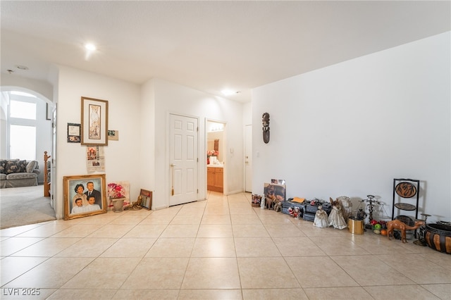 interior space featuring arched walkways and light tile patterned floors
