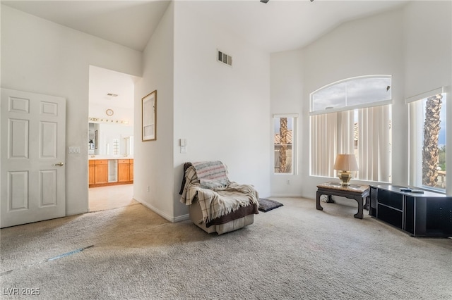 living area with high vaulted ceiling, carpet, and baseboards