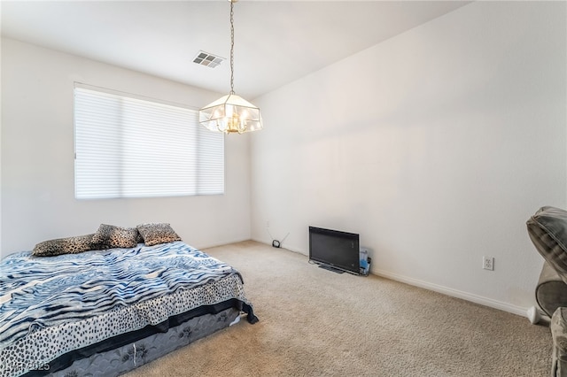 carpeted bedroom featuring a chandelier and baseboards
