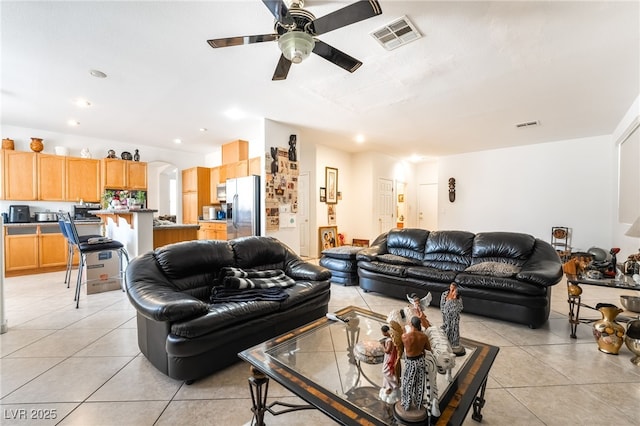 living area with light tile patterned floors, a ceiling fan, arched walkways, and recessed lighting