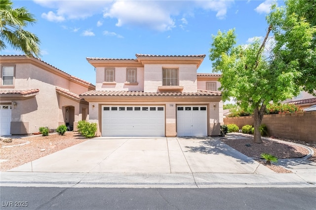 mediterranean / spanish-style house with stucco siding, a garage, concrete driveway, and a tiled roof