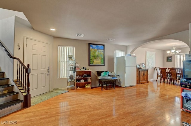 9065 W Torino Ave, Las Vegas, NV 89148 - foyer entrance featuring arched walkways, a chandelier, wood finished floors, stairs, and plenty of natural light
