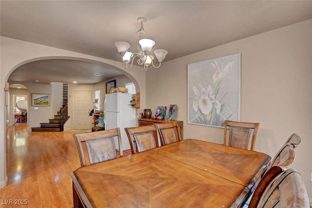 9065 W Torino Ave, Las Vegas, NV 89148 - dining room with arched walkways, a chandelier, light wood-style floors, stairs, and recessed lighting